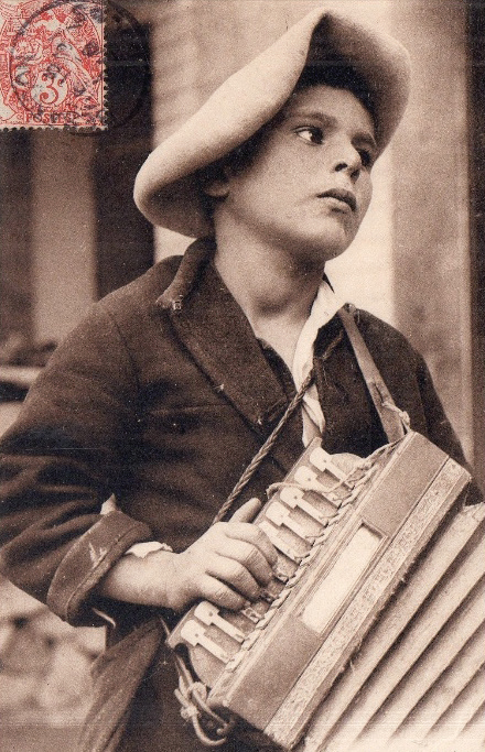 Mutiko baten gorputz erdiko erretratua, ustez soinujole ibiltaria. Postala, circa 1905. (Iturria: Lavaud, P. (2014). L'Accordéon Diatonique. Des salons mondains aux bals populaires, azala. Éditions Confluences-Les Nuits Atypiques.)